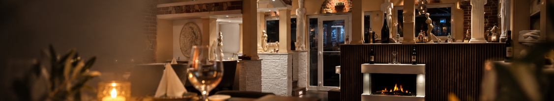 Bar mit Kaminfeuer, Statuen und Kerzenlicht